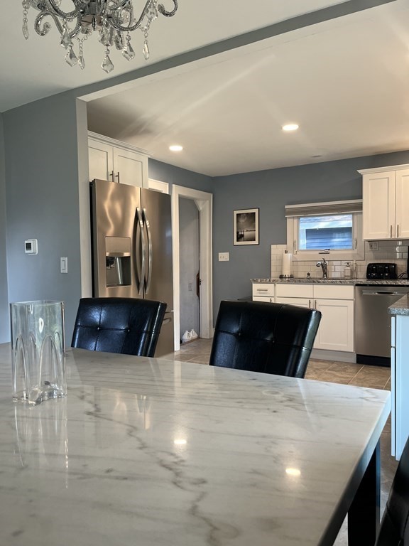 239 Plumtree Road Springfield, MA 01118 - Photo 7 of 14 a kitchen with granite countertop a refrigerator a stove and a sink with wooden floor