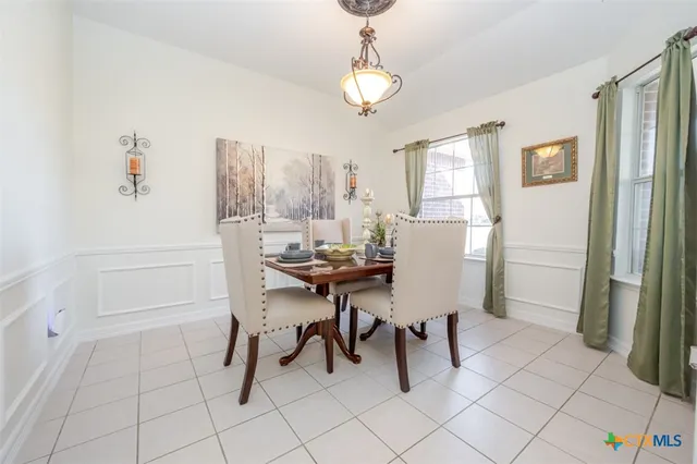a view of a dining room with furniture and a chandelier