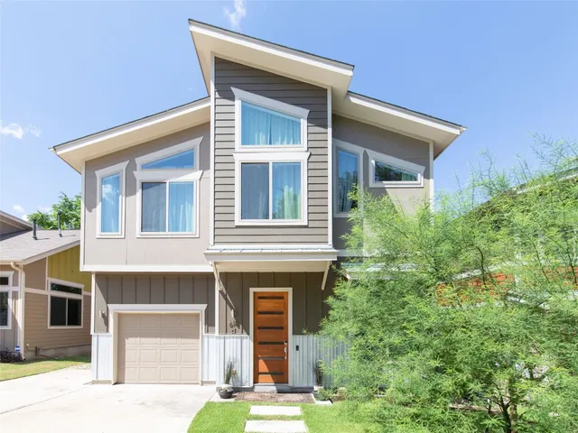 a front view of a house with a yard garage and outdoor seating