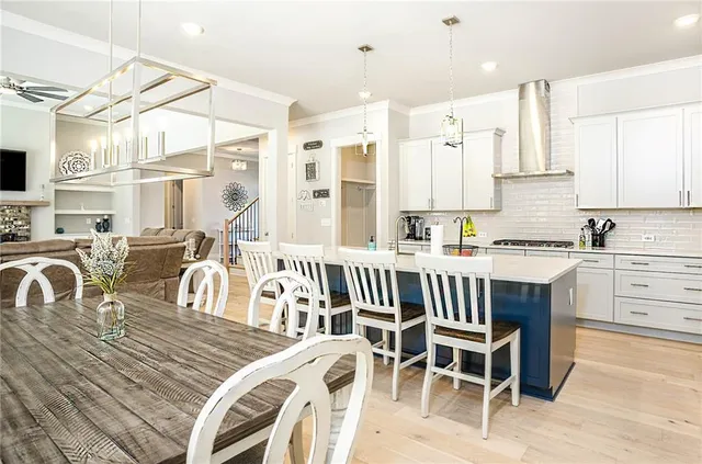 a kitchen with a dining table chairs and white cabinets