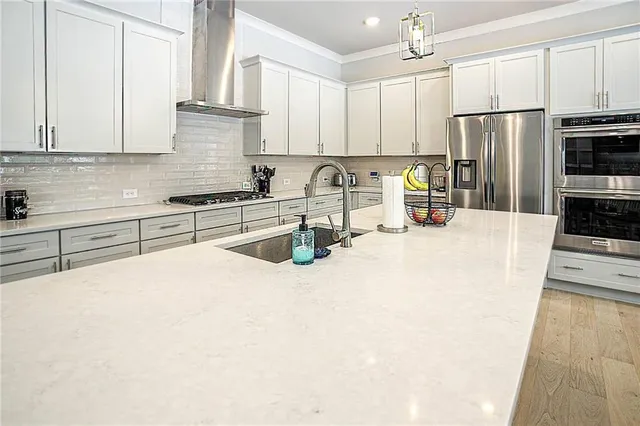 a kitchen with stainless steel appliances a refrigerator sink stove microwave and cabinets