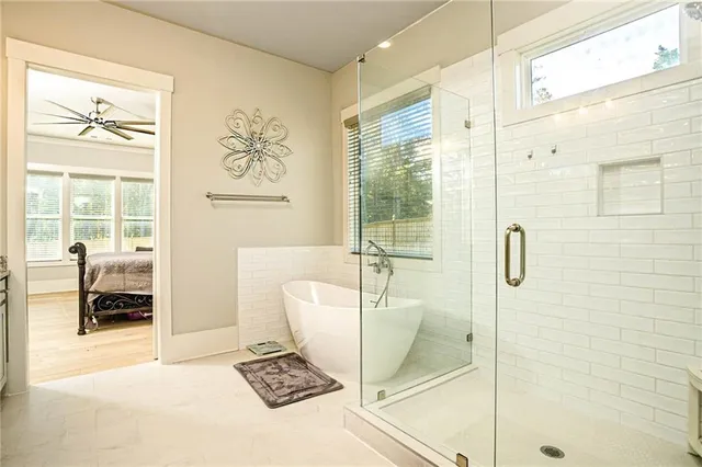 a bathroom with a tub shower and window