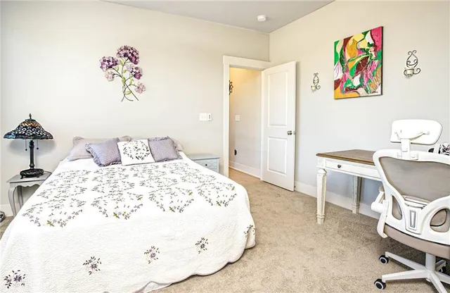 a bedroom with a bed and painting on the wall