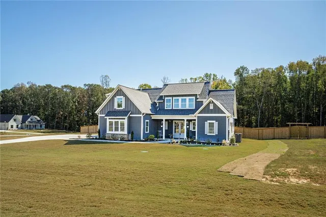 a view of a house with a big yard and large trees
