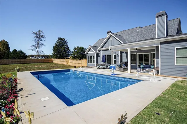 a view of a house with pool and chairs