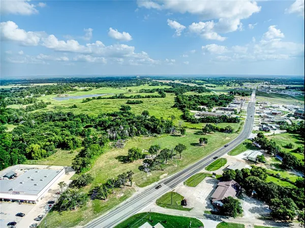 a view of a green field with lots of bushes