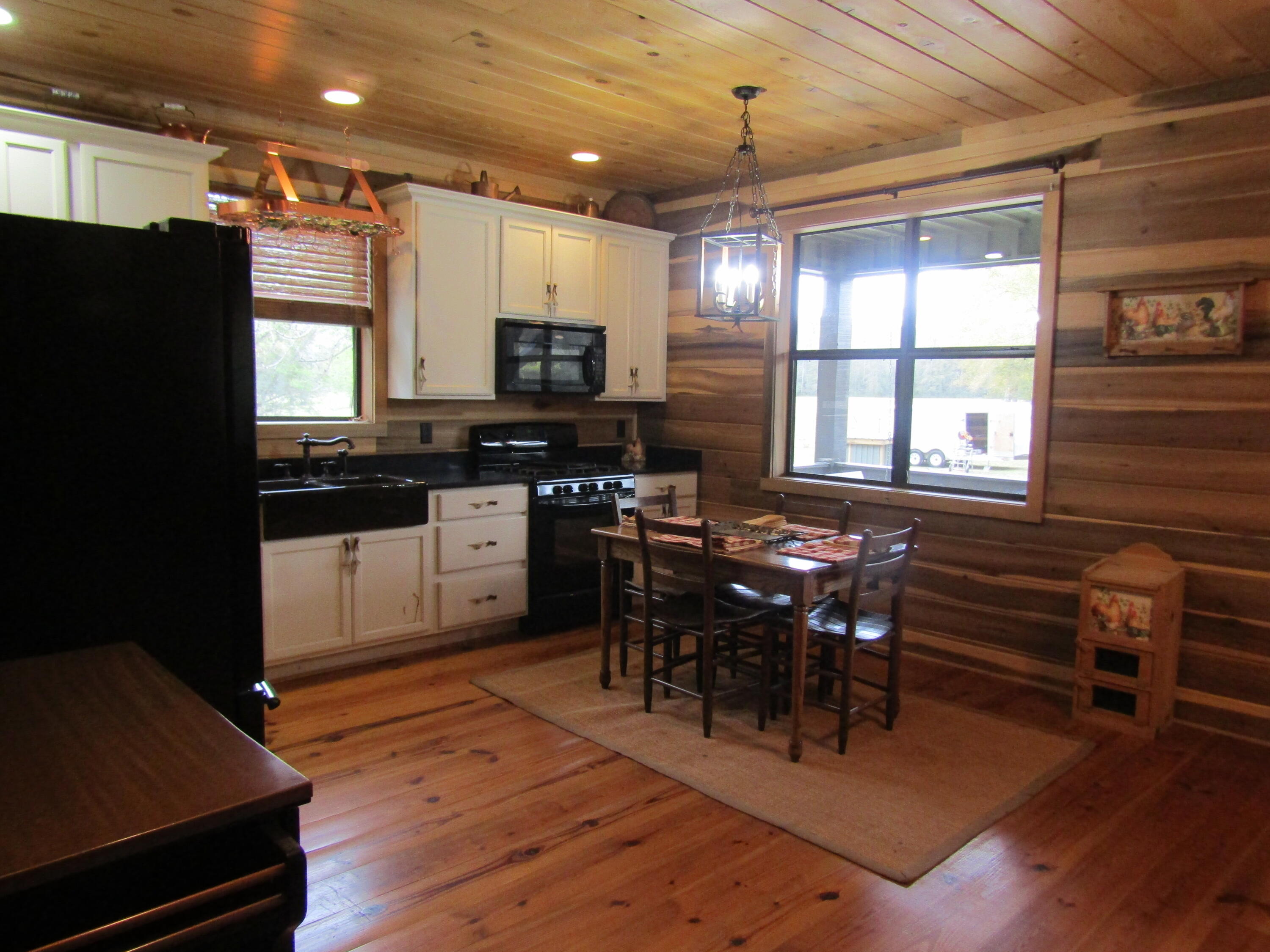 2948 Alford Road Samson, AL 36477 - Photo 15 of 121 a kitchen with stainless steel appliances granite countertop a stove a refrigerator a sink a dining table and chairs with wooden floor