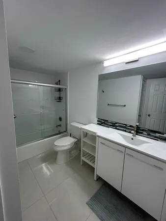 a bathroom with a granite countertop sink a toilet and shower