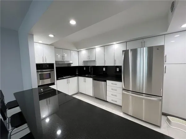 a view of a refrigerator in kitchen and wooden floor