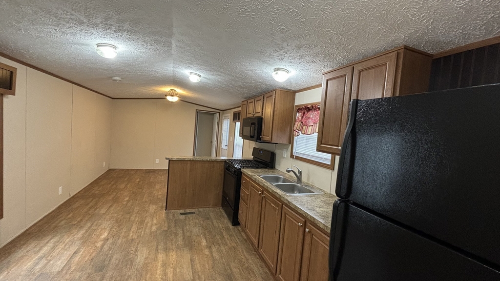 557 Southwest Cutoff, Unit 47 Worcester, MA 01607 - Photo 3 of 10 a kitchen with stainless steel appliances a refrigerator and a stove top oven