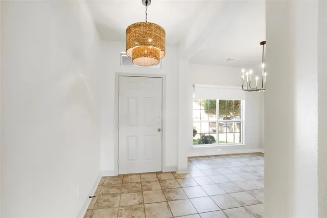 an empty room with windows and chandelier