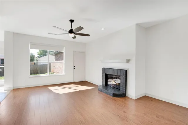 a view of an empty room with window and fire place