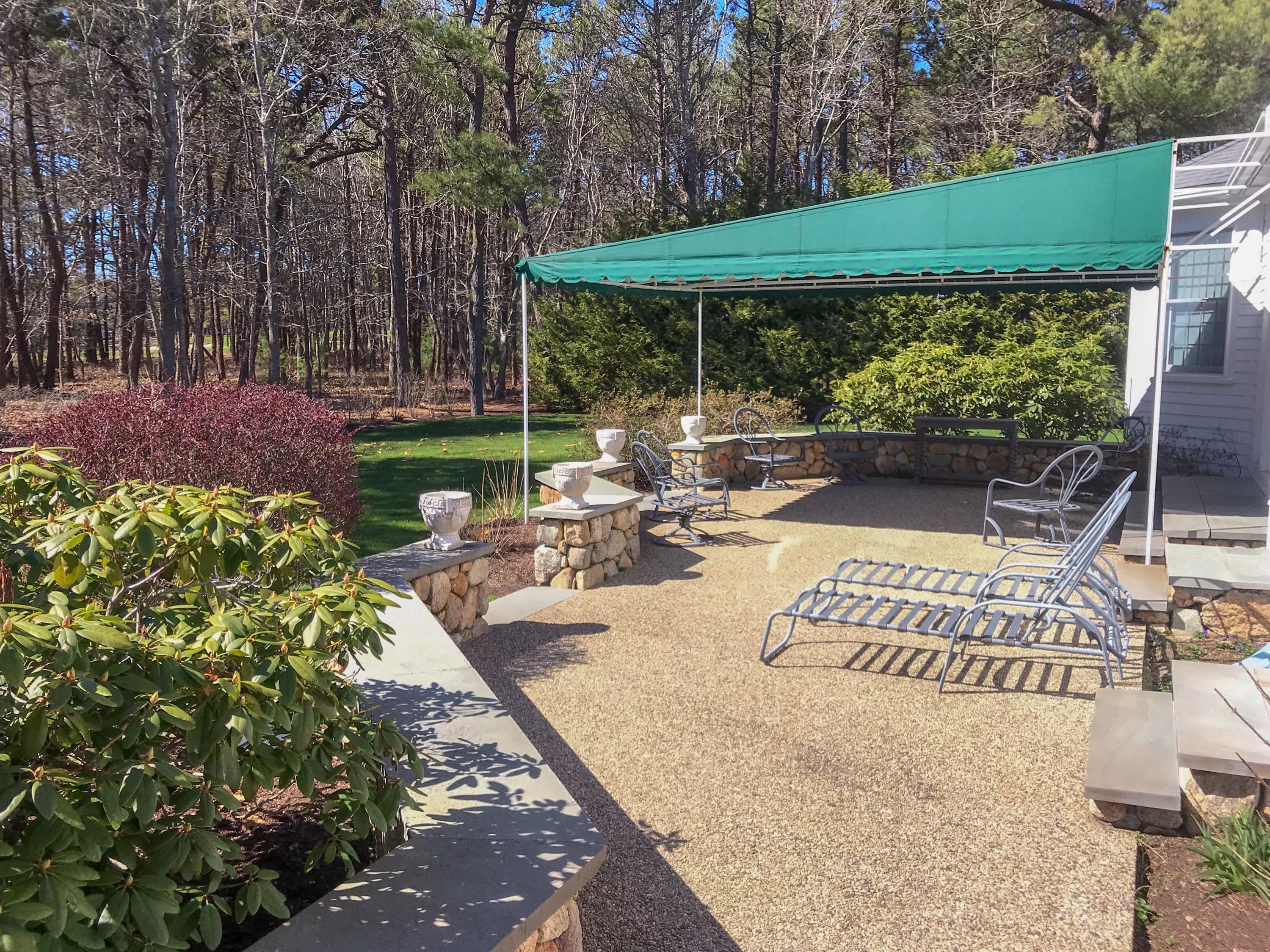 163 Pineleigh Path Osterville, MA 02655 - Photo 20 of 23 a view of a patio with table and chairs potted plants with large tree