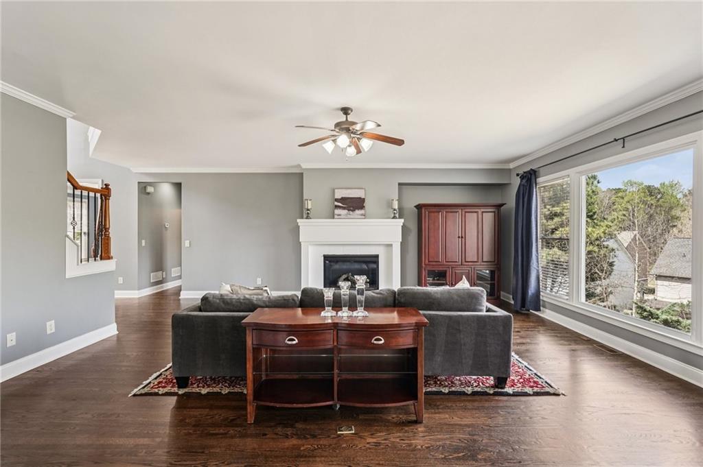 4708 Arbor Crest Place Suwanee, GA 30024 - Photo 20 of 102 a living room with furniture a fireplace and a large window
