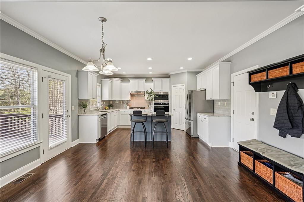 4708 Arbor Crest Place Suwanee, GA 30024 - Photo 23 of 102 a open kitchen with white cabinets and stainless steel appliances