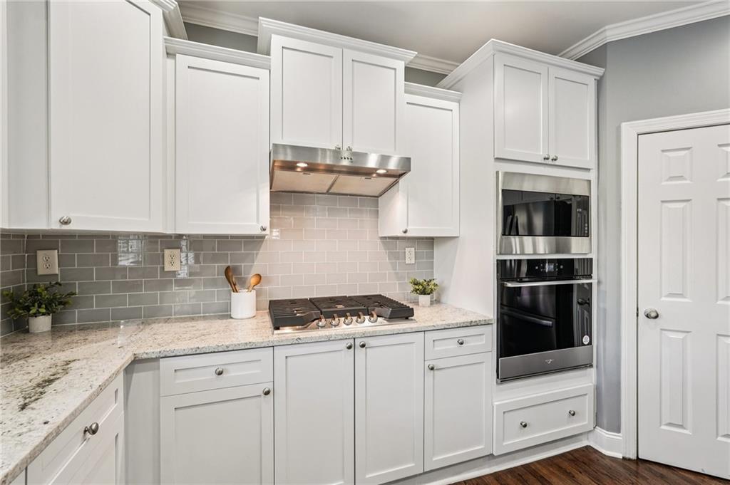 4708 Arbor Crest Place Suwanee, GA 30024 - Photo 30 of 102 a kitchen with stainless steel appliances white cabinets and a stove