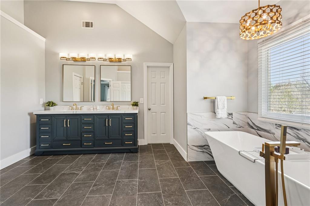 4708 Arbor Crest Place Suwanee, GA 30024 - Photo 46 of 102 a spacious bathroom with a double vanity sink a mirror and a bathtub