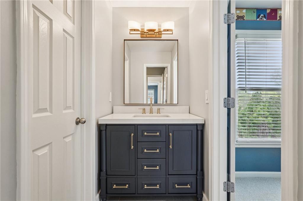 4708 Arbor Crest Place Suwanee, GA 30024 - Photo 51 of 102 a bathroom with a granite countertop sink and a mirror