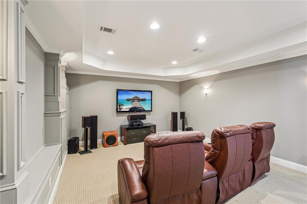4708 Arbor Crest Place Suwanee, GA 30024 - Photo 65 of 102 a living room with furniture a flat screen tv and kitchen view