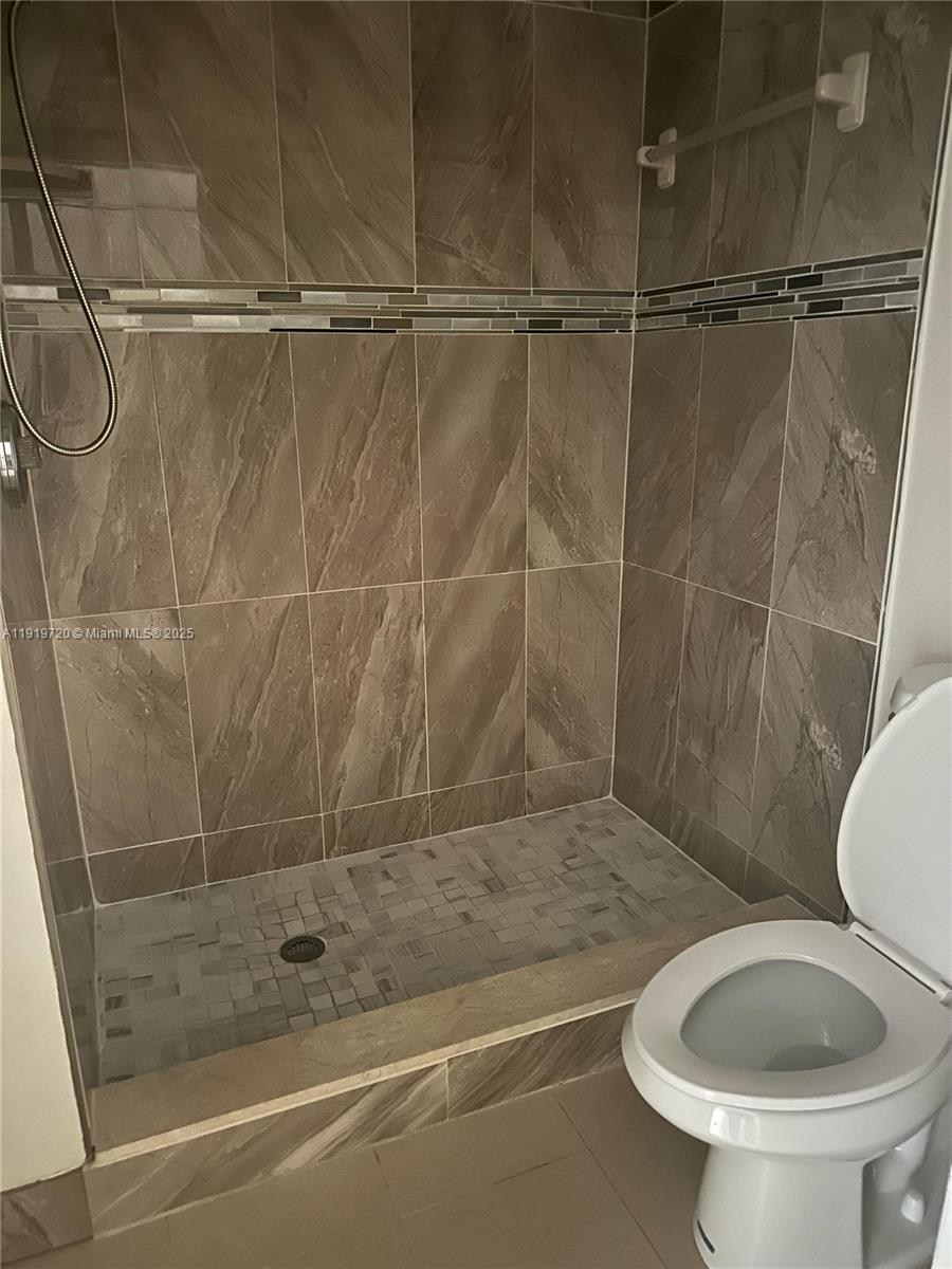 6031 10th Avenue North, Unit 218 Greenacres, FL 33463 - Photo 8 of 9 a bathroom with a toilet and a shower