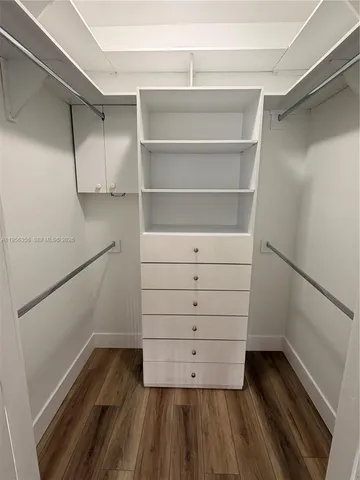 a view of walk in closet with empty racks