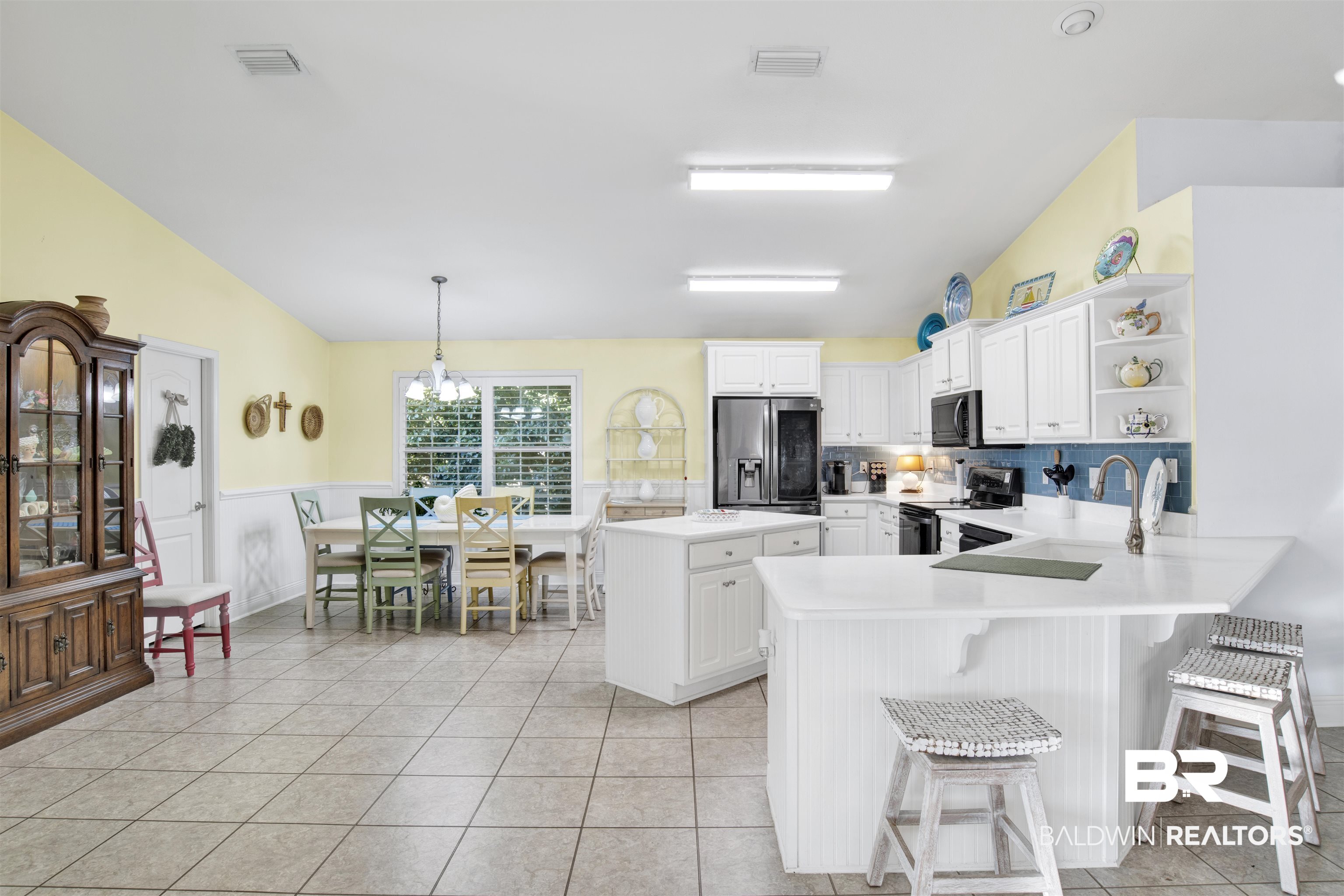 314 Blackfriars Street Fairhope, AL 36532 - Photo 10 of 25 Kitchen featuring appliances with stainless steel finishes, decorative light fixtures, a breakfast bar area, white cabinets, and kitchen peninsula