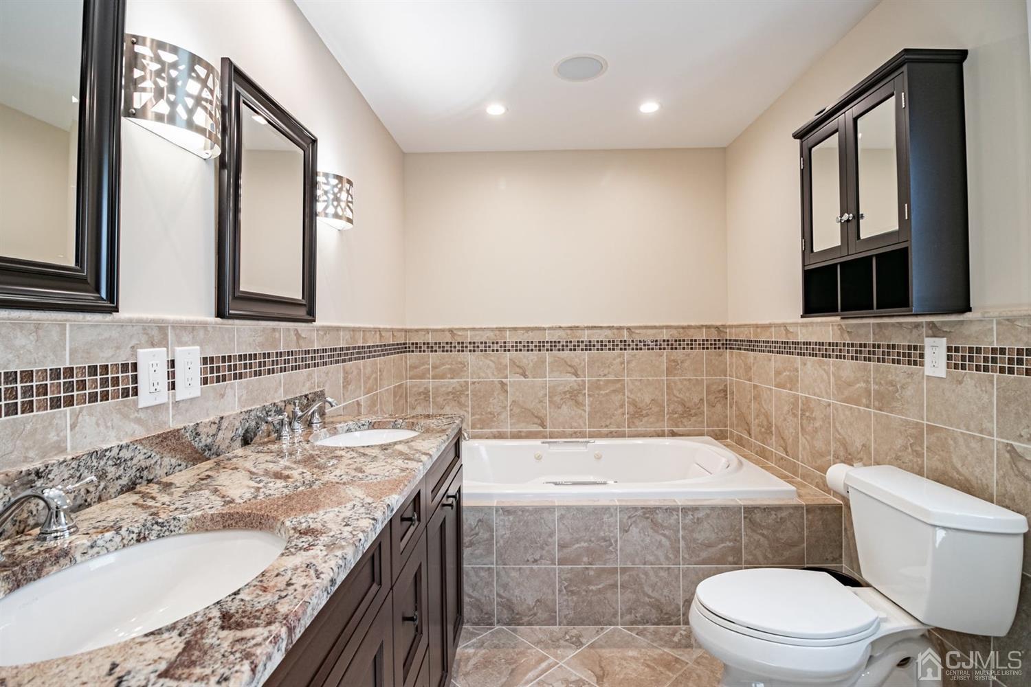 24 Kimberly Road Colonia, NJ 07067 - Photo 14 of 50 a bathroom with a granite countertop bathtub sink vanity mirror and toilet