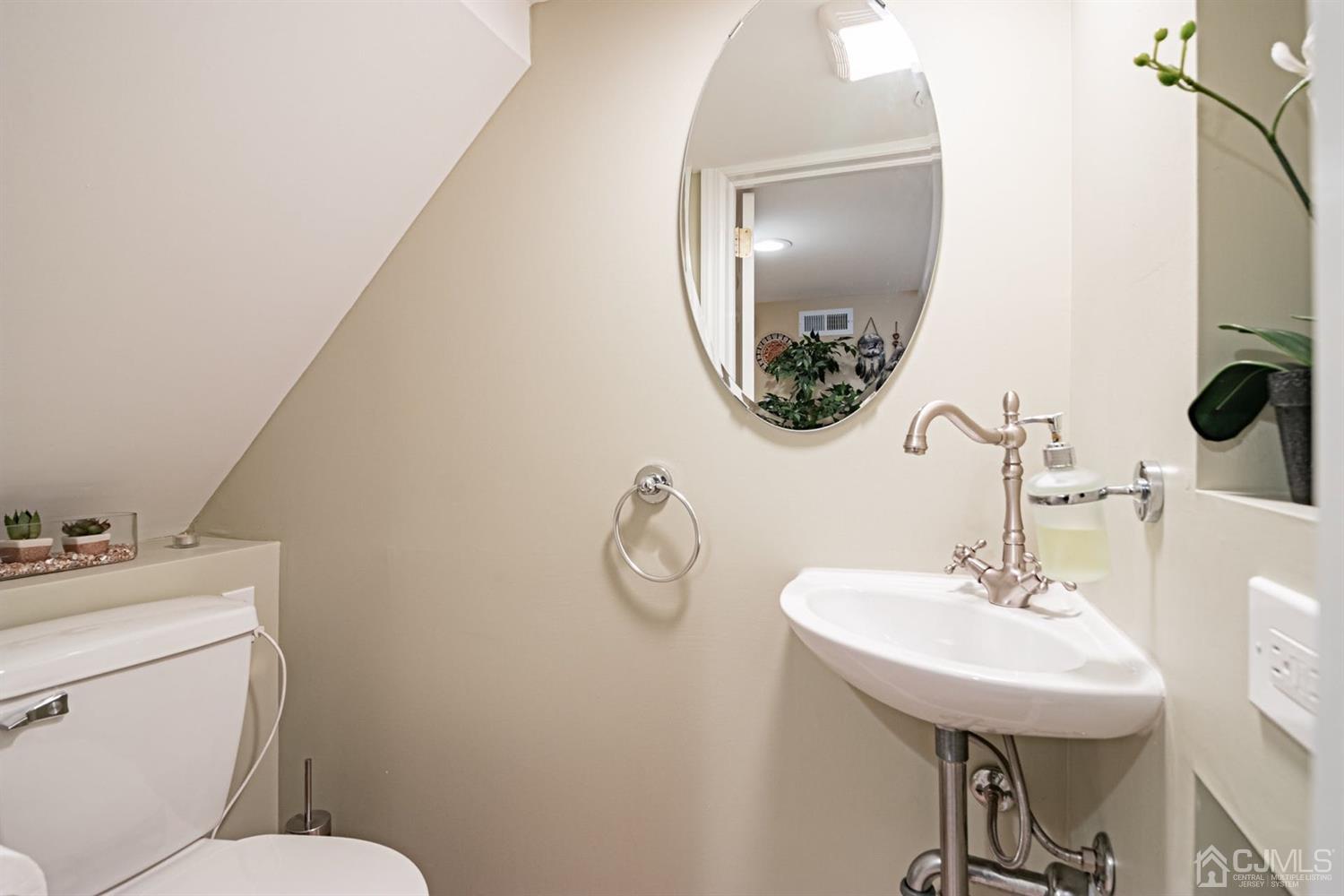 24 Kimberly Road Colonia, NJ 07067 - Photo 29 of 50 a bathroom with a toilet a sink and mirror
