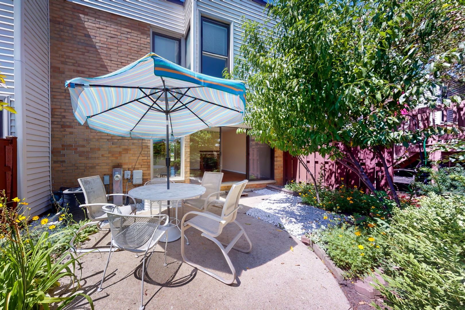 1009 Spring Mill Drive Hoffman Estates, IL 60169 - Photo 19 of 35 a view of a patio with chairs under an umbrella