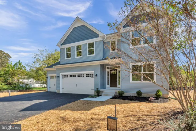 a view of a white house with large windows and a yard