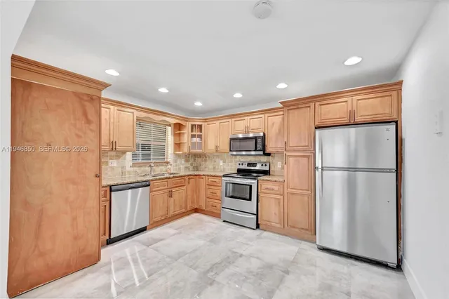 a large kitchen with stainless steel appliances granite countertop a stove and a sink