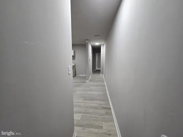 a view of a hallway with wooden floor and entryway