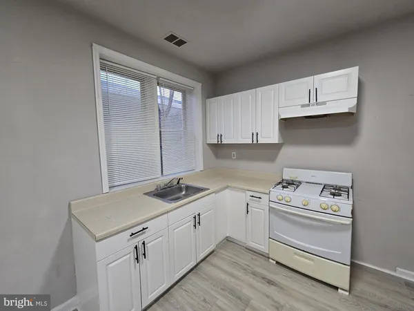 a kitchen with a sink stove and cabinets