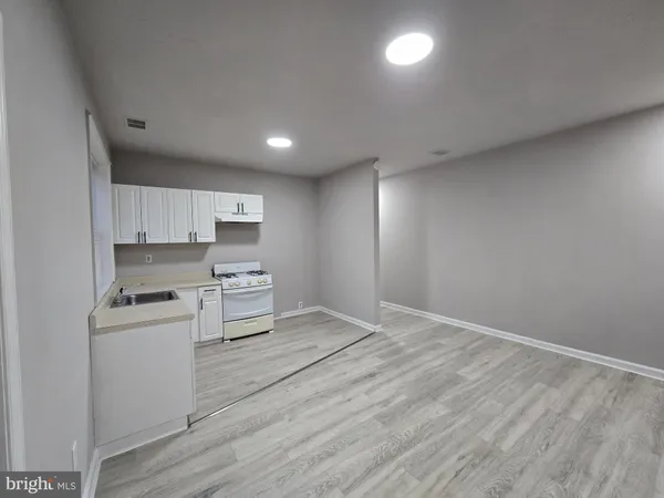a kitchen with a refrigerator and white cabinets