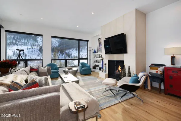 a living room with furniture a flat screen tv and a fireplace