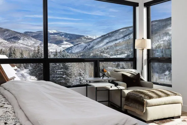 a bedroom with furniture and a large window