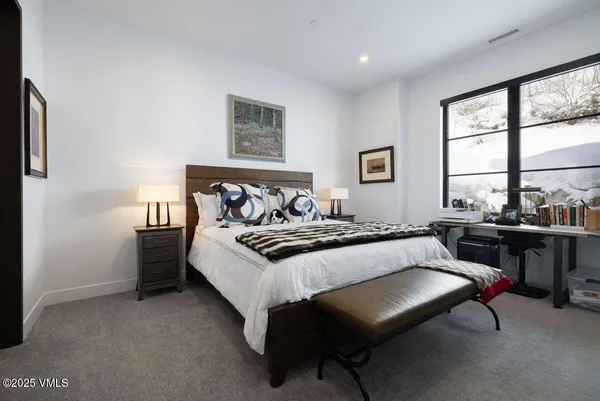 a bedroom with furniture and a large window