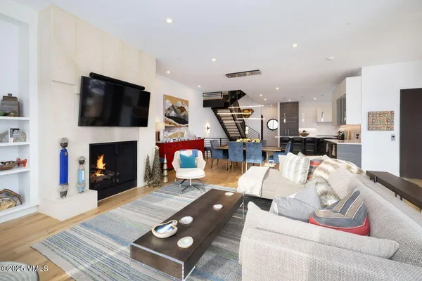 a living room with furniture a flat screen tv and a fireplace