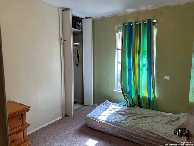 a bedroom with a bed and a window