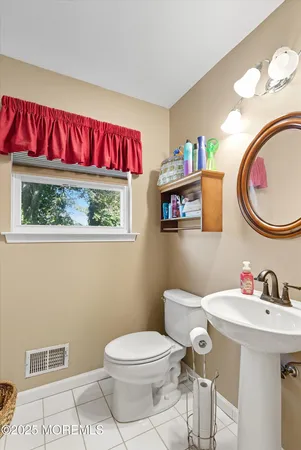 a bathroom with a toilet a sink and a mirror