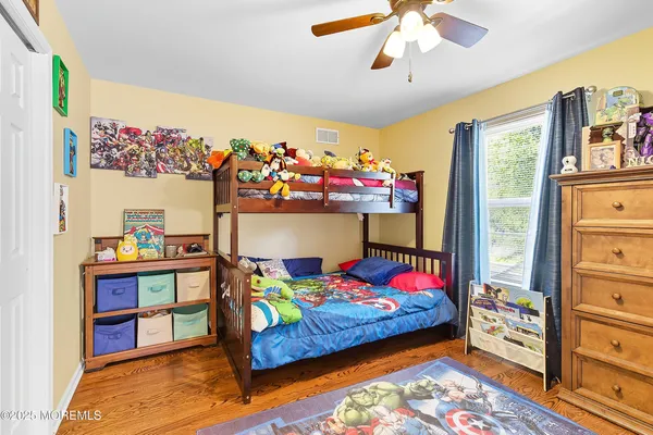 a bedroom with bed and wooden floor