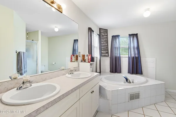 a bathroom with a double vanity sink and a mirror