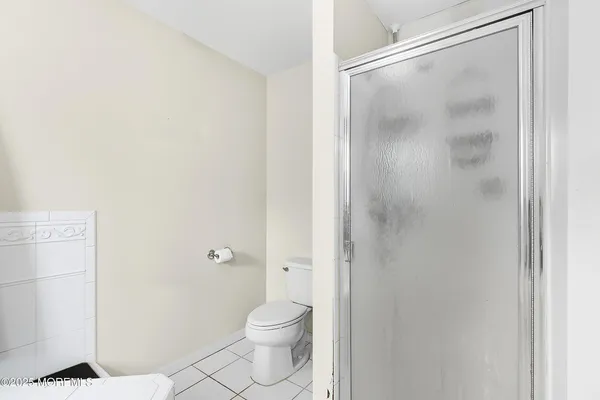 a bathroom with a granite countertop toilet and a shower
