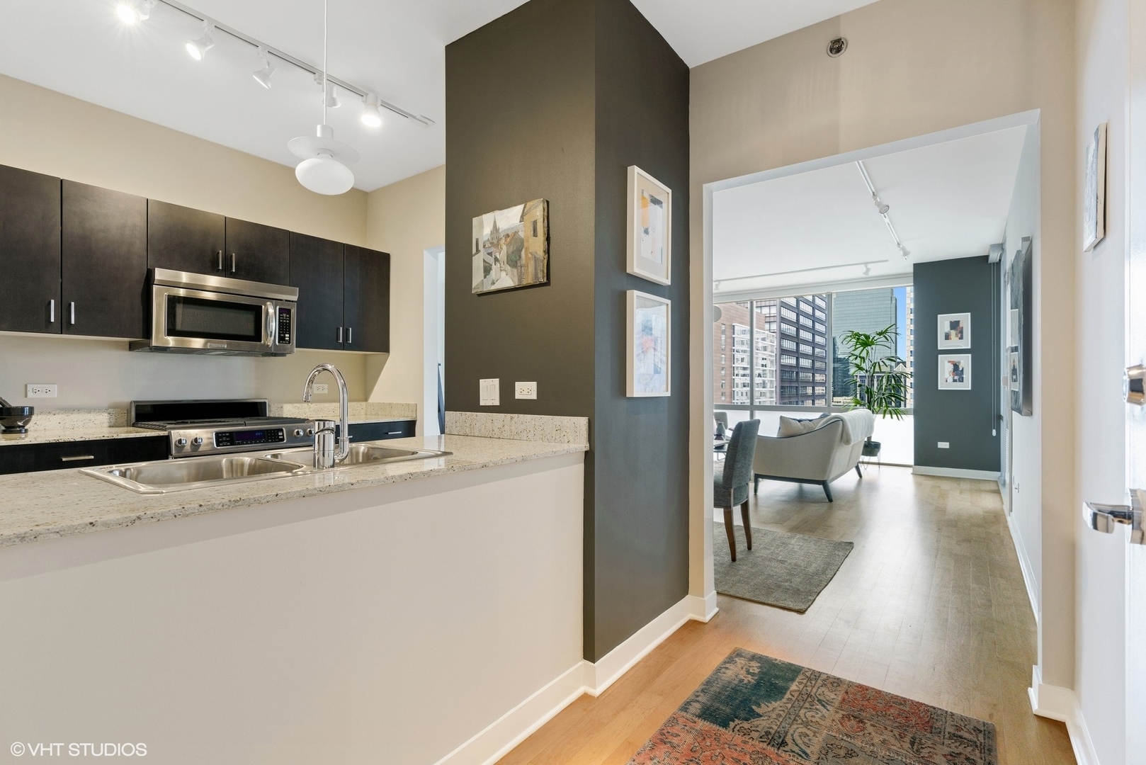 8 East Randolph Street, Unit 3207 Chicago, IL 60601 - Photo 2 of 16 a large white kitchen with stainless steel appliances granite countertop a stove a refrigerator a sink a dining table and chairs with wooden floor