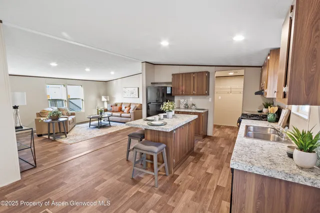 a large kitchen with lots of counter top space a sink appliances and cabinets