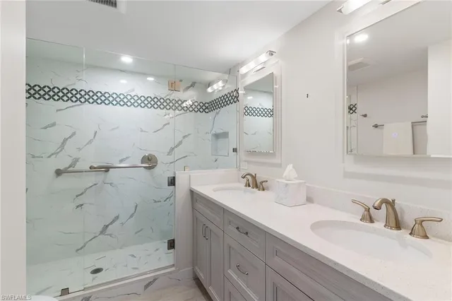 a bathroom with a double vanity sink mirror and shower