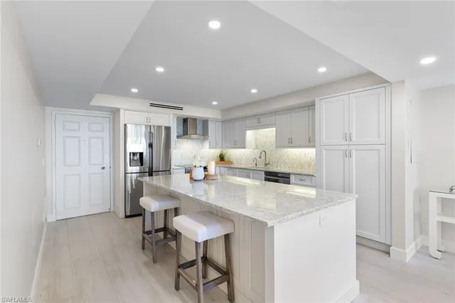 a kitchen with stainless steel appliances granite countertop a refrigerator and a sink
