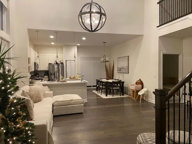 a living room with furniture a dining table and a large window