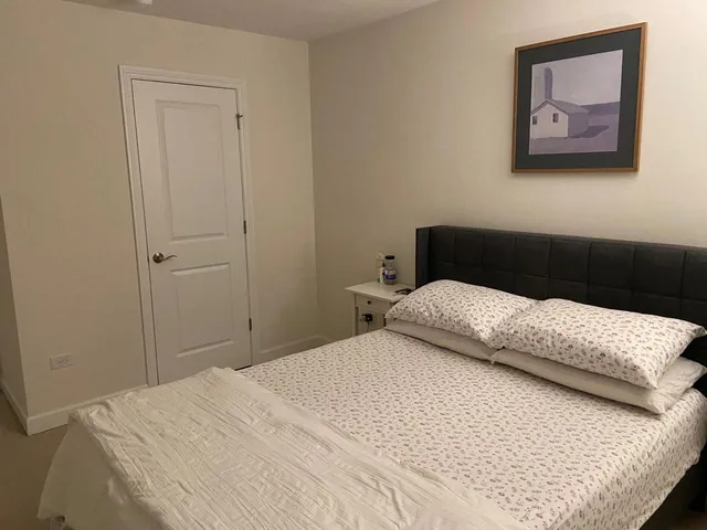 a bedroom with a bed and a painting on the wall