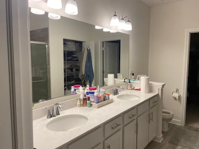 a bathroom with double vanity and a mirror